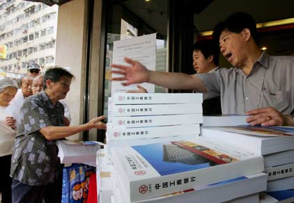 People line up outside a bank to get application forms and prospectus of the Industrial & Commercial Bank of China (ICBC) during its initial public offering (IPO) in Hong Kong October 16, 2006. ICBC, whose IPO of up to $19 billion is set to be the world's biggest, priced its A-share initial public offering at a range of 2.60-3.12 yuan ($0.33-0.39) per share, it said on Monday.