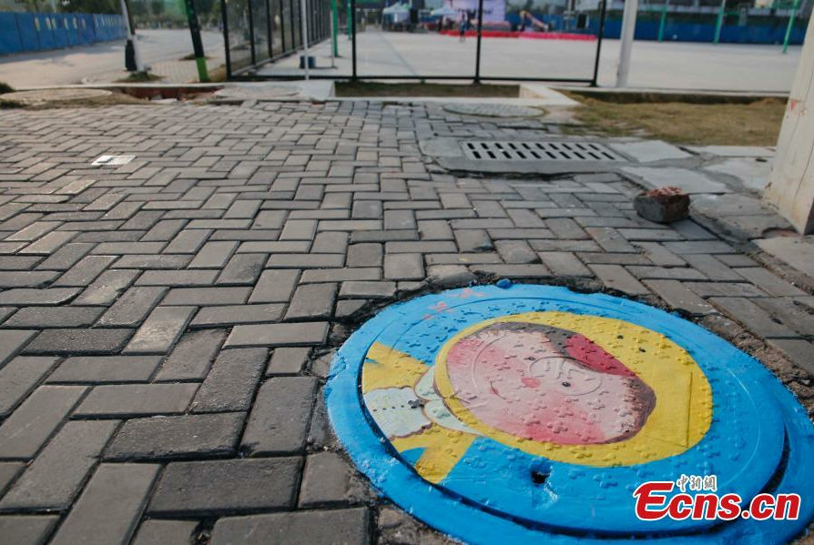 Students paint dream on manhole covers