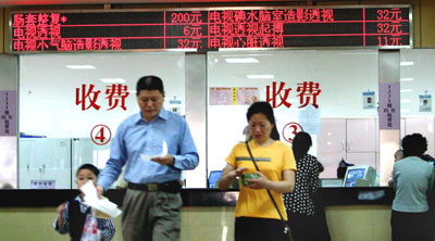 Two patients leave the payment counter at a hospital in Nanjing, capital of East China's Jiangsu Province. A lot of people complain that medical expenses are too high and they have to save more for future medical bills. [newsphoto]