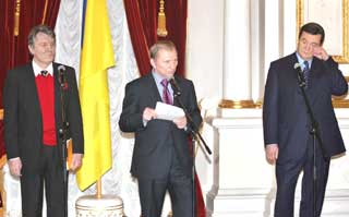 Ukraine's outgoing President Leonid Kuchma (C) delivers a speech while opposition leader Viktor Yushchenko (L) and Prime Minister Viktor Yanukovich look on after negotiations with European and Russian mediators at the presidential office in Kiev December 7, 2004. Ukraine's outgoing President Leonid Kuchma said on Tuesday he had agreed to sack the central election commission and support election law reform -- both key opposition demands to end mass protests against a rigged vote.