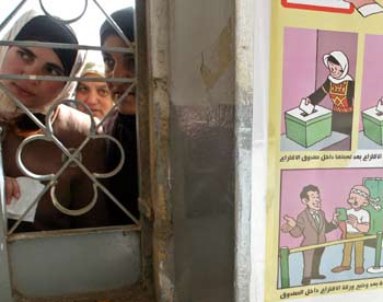 Palestinian women queue to vote in a polling station during Palestinian municipal elections in the West Bank town of Halhoul near Hebron December 23, 2004. Palestinians voted on Thursday in the first municipal elections in the West Bank in nearly three decades, a dress rehearsal for a presidential ballot next month to choose Yasser Arafat's successor. [reuters]