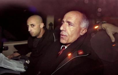 An Israeli policeman escorts detained nuclear whistleblower Mordechai Vanunu, right, as they arrive at a police station in Jerusalem late Friday Dec. 24, 2004. Vanunu was arrested at a checkpoint as he tried to travel to the West Bank town of Bethlehem to attend midnight Mass in the traditional birthplace of Christ, a police spokesman said. [AP]