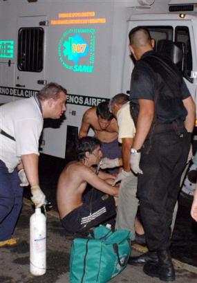 People injured in a nightclub fire are helped outside the nightclub in Buenos Aires, Argentina, Friday, Dec. 31, 2004. The fire swept through the crowded nightclub, killing at least 174 people and injuring more than 410, police said Friday. The blaze broke out during a rock concert at a popular nightclub. [AP]