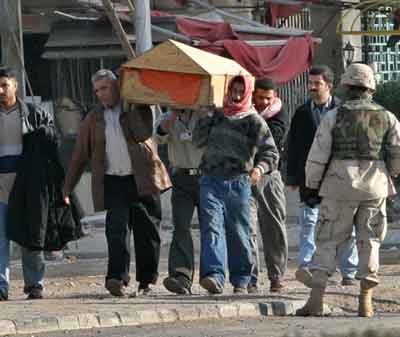 U.S. Army soldiers watch as Iraqi men carry the coffin of a friend killed in a suicide car bomb attack near the Australian embassy in Baghdad January 19, 2005. Suicide car bombers attacked the Australian embassy and a police headquarters in Baghdad on Wednesday, killing at least seven people in the latest deadly guerrilla strikes before Iraq's January 30 elections. [Reuters]