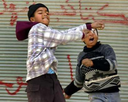 Palestinian boys hurl stones at an Israeli army vehicle during clashes in the Balata refugee camp near the West Bank City of Nablus January 17, 2005. Palestinian militants fired more rockets and mortars into Jewish settlements in Gaza on Tuesday, hours before new President Mahmoud Abbas was due in the area to urge a cease-fire he hopes could revive peacemaking with Israel. A dozen rounds caused no casualties settlers said. (Abed Omar Qusini/Reuters) 