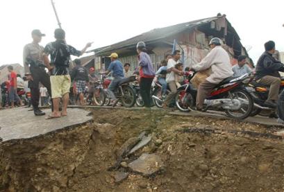 Motorcycle traffic clogs what is left of the earthquake-damaged streets, Wednesday, March 30, 2005, in Gunung Sitoli on Nias Island, Indonesia. The massive earthquake late Monday killed hundreds and sparked fears of another tsunami in the region. (AP Photo/Suzanne Plunkett) 