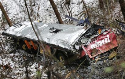 A Swiss tour bus lays on the bank of the Dranse river after an accident on the road to the Great St. Bernard pass between Orsieres and Liddes, western Switzerland, Sunday, April 17, 2005. According to police information the bus with 27 travellers on board went off the road and fell over a slope about 800 feet (243 meters) into a ravine. Police say twelve people died in the crash and 15 are injured. (AP Photo/Keystone, Fabrice Coffrini) 