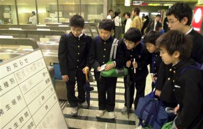 Japanese students take a close look at the notice board on the train service that was suspended following an earthquake at a railway station in Fukuoka, southern Japan, on Wednesday April 20, 2005. An earthquake with a preliminary magnitude of 5.8 struck southern Japan on Wednesday, swaying buildings and shattering windows. Six people were reported injured, but there was no danger of a tsunami. (AP