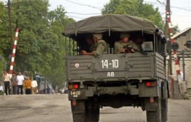 A military truck carries Uzbek soldiers on a road about 20 km (12 miles) outside the eastern Uzbek city of Andijan, Sunday, May 15, 2005. Security was tight in Andijan, Uzbekistan's fourth-largest city, as stunned residents cleaned blood off streets guarded by troops. [AP]