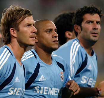 From left 
 to right, Real Madrid soccer players David Beckham, Robert Carlos, Figo take part in an exhibition game in Tianjin, a coastal city in North China, July 22, 2005. Real Madrid are to face Beijing Guoan in a friendly match at Beijing Workers' Stadium on Saturday, July 23, 2005. [Xinhua]