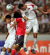 North Korea's Pak Chol-jin (R) heads the ball over teammate Cha Jong-hyok (L) and South Korea's Kim Mi-jung in the second half their East Asian Football Championship match in Chonju, South Korea August 4, 2005. 