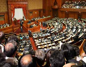 Japanese lawmakers cast their ballots in a key vote on bills to privatise the postal system as local media crowd around the assembly hall at the Upper House of Parliament in Tokyo August 8, 2005. Prime Minister Junichiro Koizumi suffered a big defeat on the vote, and will call a snap election for parliament's powerful lower house, public broadcaster NHK said.