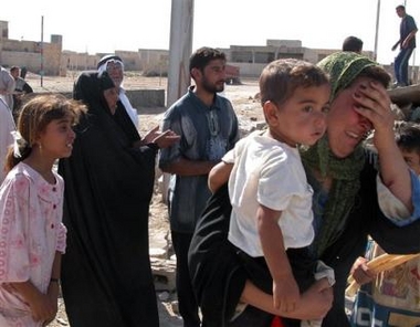 Residents and neighbours gather around a house damaged in a rocket attack in Al-Tameen near Ramadi, some 113km (70 miles) west of Baghdad, Friday, Aug. 19, 2005. The home was hit by a rocket while people were away and nobody was injured. (AP