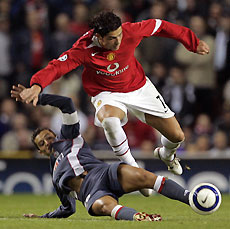 Manchester United's Cristiano Ronaldo (R) is tackled by Benfica's Simao Sabrosa during their Champions League Group D soccer match at Old Trafford, northern England, September 27, 2005.