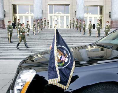 Chinese honour guard remains at attention as the U.S. presidential seal flies on U.S. President George W. Bush's limousine following his arrival at Great Hall of the People for a meeting with Chinese President Hu Jintao in Beijing, November 20, 2005. Bush pressed Hu on Sunday to rein in China's swelling trade surplus and push forward currency reform after calling for greater religious freedom. 