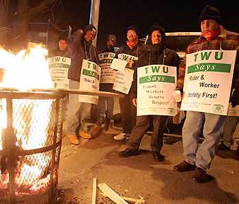 Transit workers on strike warm themselves by a fire during the evening rush hour in New York on December 21, 2005. New York transit workers walked off the job on Tuesday for the first time in 25 years, stranding millions of people who rely on the bus and subway system each day. 