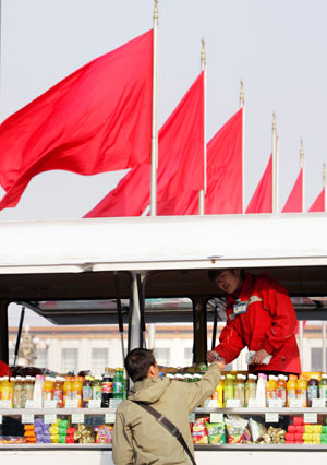 A Chinese tourist buys a drink at a temporary stall at the Tiananmen Square in front of the Great Hall of the People, the venue of the National People's Congress (NPC), in Beijing March 7, 2006. The NPC meets annually in March to pass bills, approve the budget and endorse personnel nominations