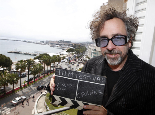 Tim Burton holds a film clapper in Cannes