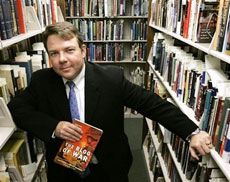 Author Matthew Currier Burden stands at the Pritzker Military Library with a copy of his book containing a collection of entries from bloggers who served in the war called , 'The Blog Of War,' in Chicago, Ill., in this Oct. 26, 2006 file photo. From the front lines of Iraq and Afghanistan to here at home, soldiers blogging about military life are under the watchful eye of some of their own. (AP